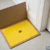 How to use glue trap for rats — glue pad placed by a door corner with a small peanut bait in the centre